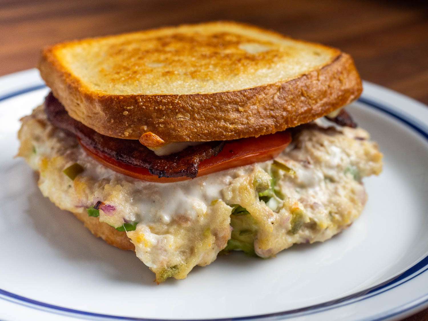 Fully Loaded Tuna Melt With Bacon, Pickled Peppers, Avocado, and Tomato Recipe Image